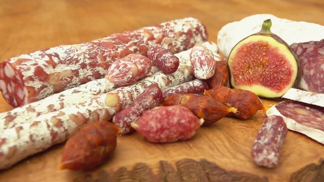 Jerked sausages and figs on a wooden board