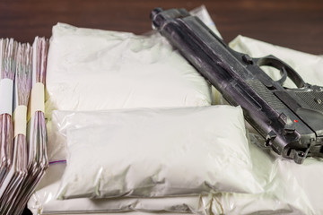Bags of drugs, pistol and money on table