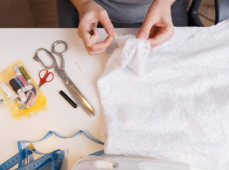 Fototapeta premium Seamstress unrips fabric near sewing-machine