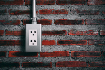 Electrical Socket on the brick wall in the gloomy tone