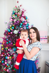 woman with a baby in a Christmas tree