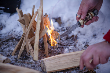 man kindles a fire in the winter forest. fire in nature. Bonfire in the forest. Winter forest