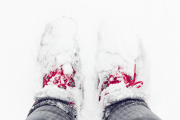 Red shoes in a deep snow, covered with a snow. Winter concept