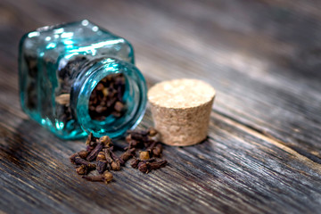 Cloves aromatic flower buds on wooden background