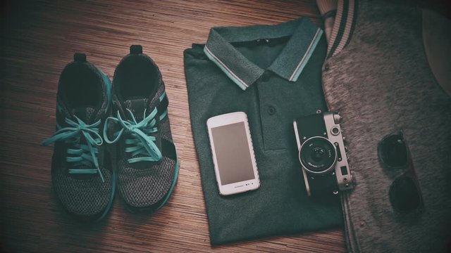 Sport clothes and gadgets, a man puts his shoes, top view
