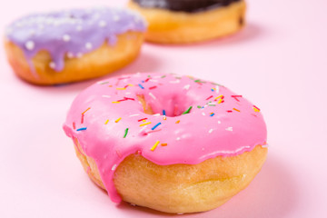 Pink round donut on pastele background. Closeup