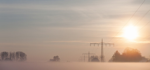 Power supply lines in the fog during winter