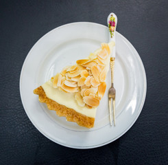A slice baked cheese cake with hazel nut on top. Tasty, fresh and healthy.