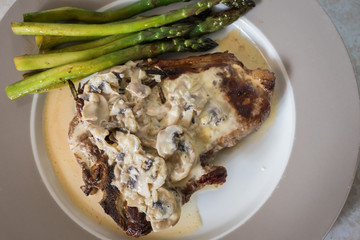 Grilling steak with rosemary, mushroom sauce and asparagus. Fresh, delicious, spicy, juicy meat, healthy.