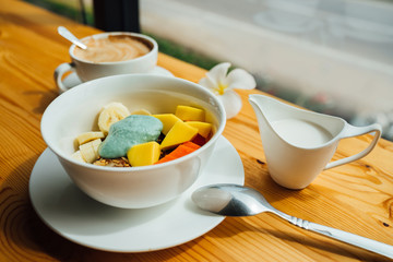 Breakfast of fresh vegetables banana, mango, seeds, oatmeal, spices, coconut milk and coffee. Useful calories.