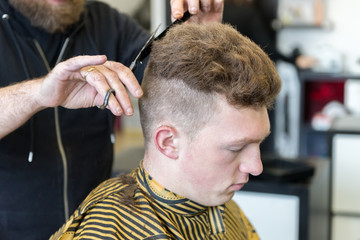 young man on a haircut in the barber shop