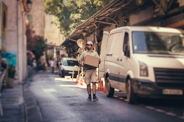 Messenger Delivering Parcel, Walking In Street Next To His Van © nullplus