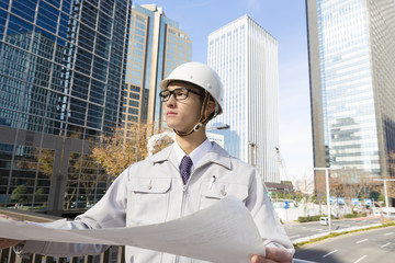 ビジネスマン　働く人　図面を見てうなずく　ヘルメット　作業服　ネクタイ　設計　建設業　新宿