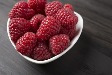 raspberries in white bowl