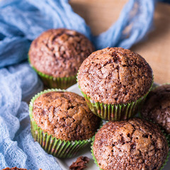 Chocolate banana muffins with sugar topping on dark blue background. Home made single portion snack. Winter baked dessert. Square