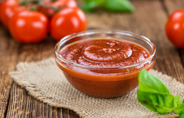 Tomato Ketchup (selective focus) on vintage wooden background