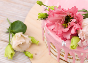 Beautiful flowers on a pink cake closeup.