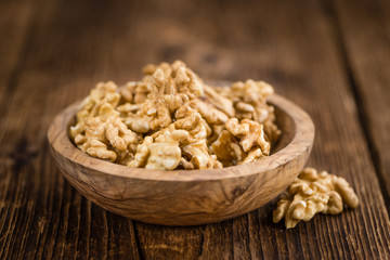 Portion of Cracked Walnuts on wooden background (selective focus