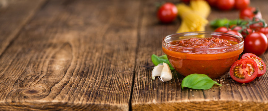 Wooden table with Tomato Sauce (selective focus)