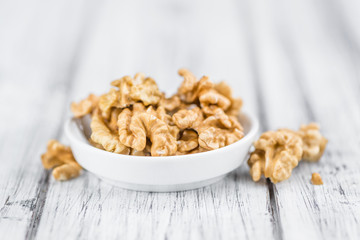 Portion of Cracked Walnuts on wooden background (selective focus