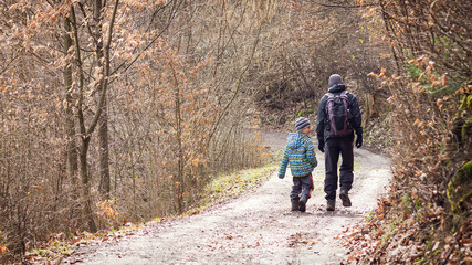 Father and son walking on forest road