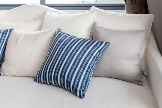 modern living room with row of white and blue pillows on sofa