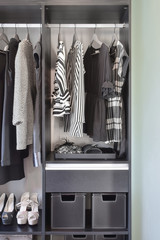 modern closet with row of black dress and shoes in wardrobe.