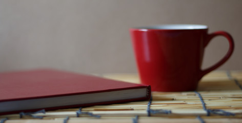 Hot coffee and a book on a wooden table.