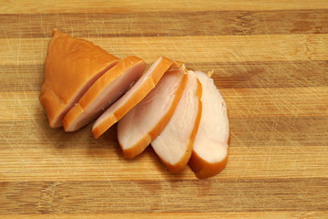 Sliced chicken ham on wooden background