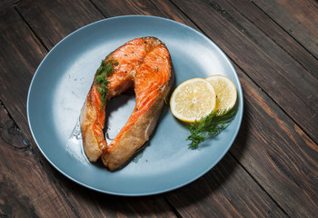 Grilled salmon with lemon on wooden background