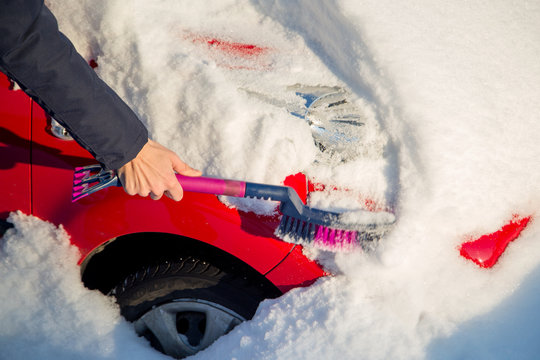 Man Brushing Snow From Car After Heavy Snowfall