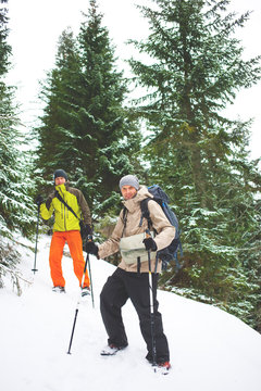 Friends with backpacks in the mountains in winter.