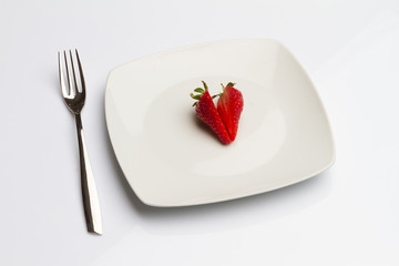 Strawberry in plate with fork isolated