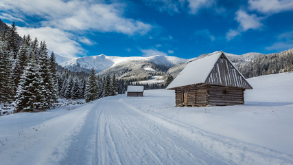 Wooden cottages and snowy road in winter, Tatra Mountains