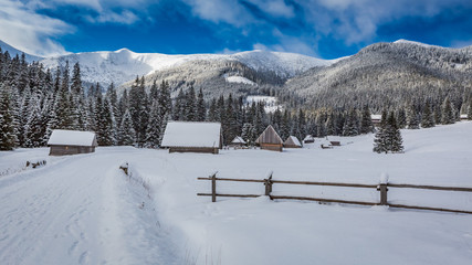 Cottages covered by snow at sunrise in winter, Tatra Mountains © shaiith