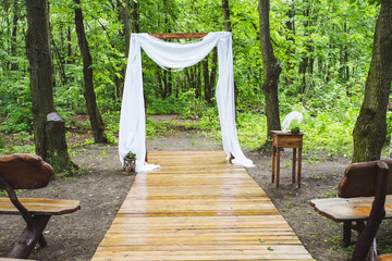 arch for the wedding ceremony, is in a pine forest