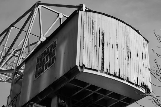 Stillgelegter Kran aus Metall mit Holzvert&auml;felung im Hafen. schwarzwei&szlig;. SW.