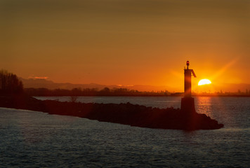 Fraser River Sunrise, Richmond, BC. Sunrise behind a navigation aid on the Fraser River. Vancouver, British Columbia, Canada. 

