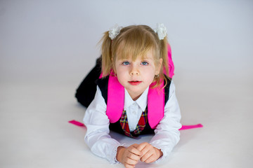 portrait of young lying schoolgirl with schoolbag