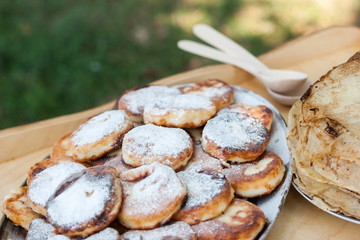 cheesecake and pancakes on the wooden table.