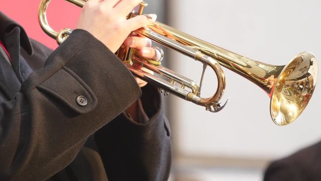 Man playing trumpet at street.
