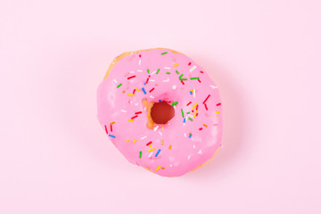Pink round donut on pastele background. Flat lay, top view.
