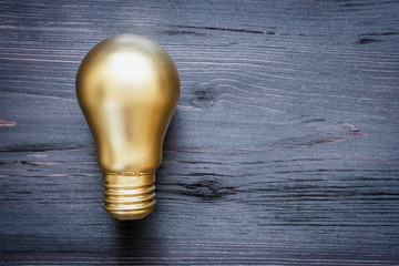 Gold bulb on a black wooden background
