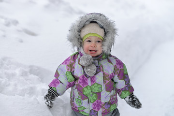 Fototapeta na wymiar Happy little boy is playing with snow on winer background