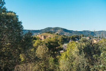 trees in the foreground and mountains in the background - nature scene at barcelona