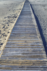 Spanish beach with Wooden walkway. Malvarrosa beach on mediterranean seacoast during winter, Valencia, Spain
