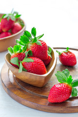 Wooden bowl with a luscious garden strawberries closeup, selecti