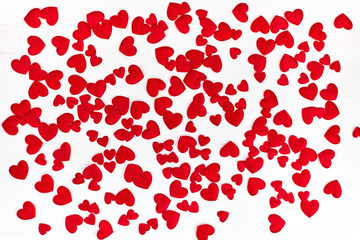 Valentines Day background with hearts. Red satin hearts on white wooden background