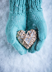 Female hands in teal knitted mittens with a entwined vintage rom