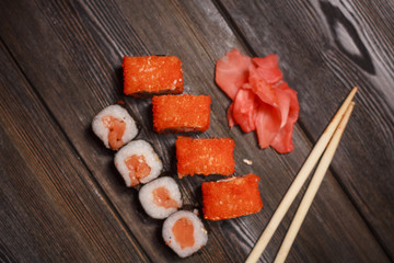 set, chopsticks, Chinese food, delicious sushi and rolls on a wooden background